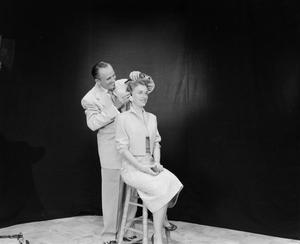 [Photograph of Vernon Isbell fixing a model's hair]