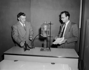 [Photograph of two men conducting an experiment]