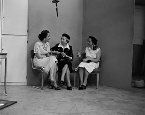[Photo of three women seated together]
