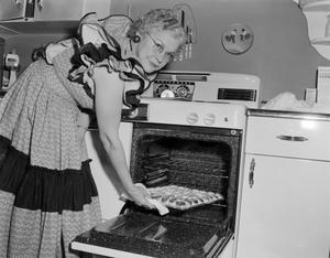 [Photograph of a woman baking biscuits]