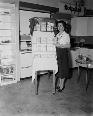 [Margaret McDonald posing with a Domino Sugar display]