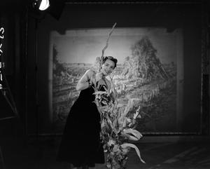 [Photograph of Ann Alden holding some corn stalk plants]