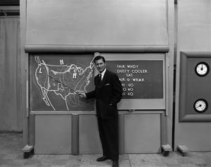 [Photograph of Larry Morrell and weather board]