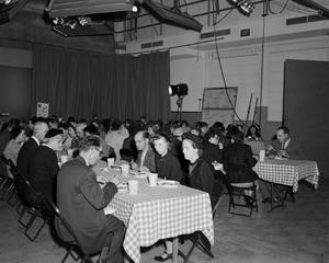 [Photograph of people eating at a table]