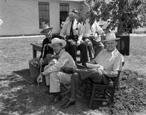 [Photograph of men sitting outdoor]