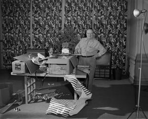 Primary view of object titled '[Photograph of Mr. Cranston with open Christmas gifts]'.