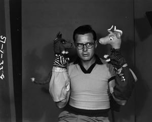 [Dean Raymond posing with puppets]