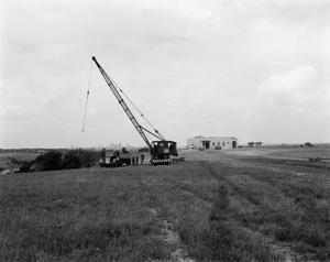 [Photograph of crane and tower in field]