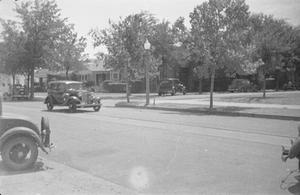 [Photograph of automobiles in a neighborhood]