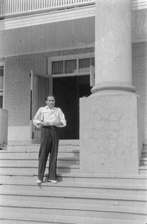 [Photograph of a man standing on porch steps, 2]