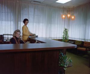 [Two women at reception desk]