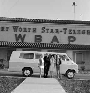 [Four individuals standing in front of a van]