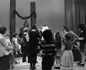 [Photograph of children gathering around Santa at a KXAS Christmas Children's Hour party]