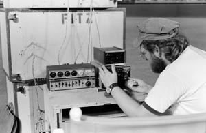 [Photograph of a man working with sound equipment]