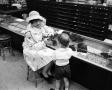 Photograph: [A women and a child at a store, 9]