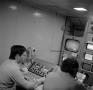 Photograph: [Two employees in a control room]