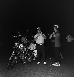 [Two individuals with a motorcycle]