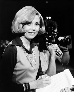 [Photograph of Sharon Noble posing with a notepad]