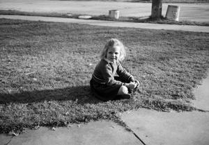 [Photograph of Carol Williams sitting in a front lawn, 2]