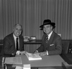 [Photograph of two men sitting at a table together]