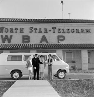 [Four individuals standing next to a van]