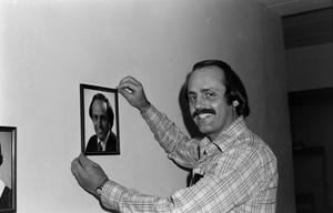 [Bill Kelley putting up a framed portrait at KXAS]