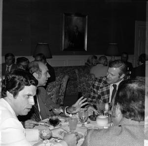 [Photograph of a group of individuals at a table at an event]