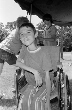 [A young boy in a wheelchair]