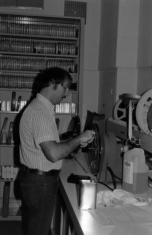 [Photograph of man with film reels]