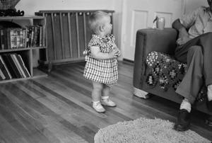 [Photograph of a baby in a living room]