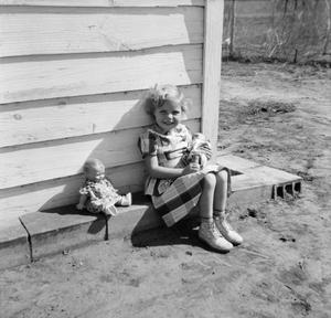 [Photograph of Carol Williams sitting outside with dolls]