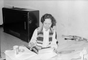[Woman reading papers at KXAS]
