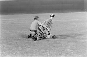 [Photo of a man under arrest on the field]