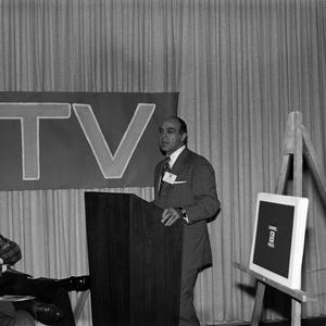 [Photograph of a man at a podium at a KXAS-TV event]