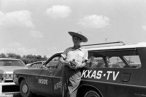 [Photograph of Wayne Brown next to a WBAP news vehicle]