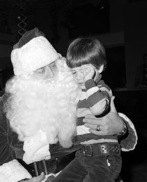 [Photograph of Santa holding a young boy at a KXAS Christmas Children's Hour party]