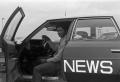 Photograph: [KXAS employee sitting in a news automobile]