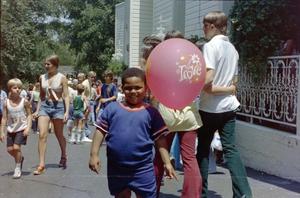 [A young boy holding a balloon at Six Flags]