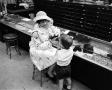 Photograph: [A women and a child at a store, 8]