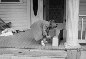 [Photograph of Carol Williams playing on a porch]