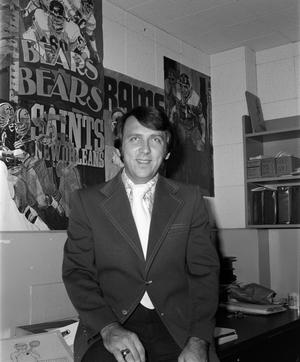 [Ron Spain in front of football posters]