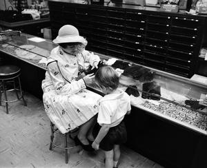 [A women and a child at a store, 7]