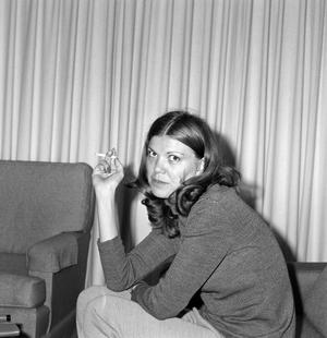 [A woman holding a cigarette]