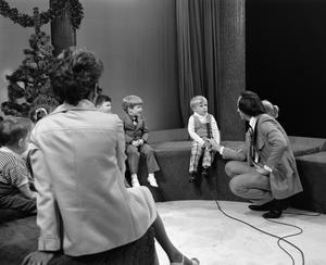 [Photograph of Bill Kelley talking to a little boy at a KXAS Christmas Children's Hour party]