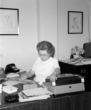 [A woman looking at a booklet]