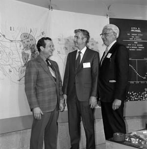 [Men in front of a weather map]