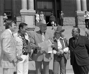 [Bill Mack, Sheriff Low Evans, Miss Ford Country, and Chubby Wise in front of the Tarrant County Courthouse]