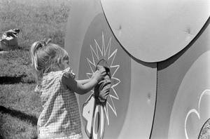 [A child playing a carnival game]