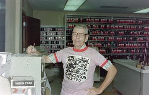 Primary view of object titled '[A staff in office wearing KXAS Super Season T-shirts]'.