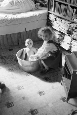 [Photograph of Carol Williams giving a doll a bath]